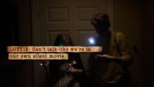 Une capture d’écran de Lottie et Joe se servant de leur lampe de  pour explorer la salle d’entreposage plongée dans l’obscurité.