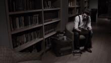 L’écran montre Joe assis à la bibliothèque, sa chaise entourée d’une multitude de livres.