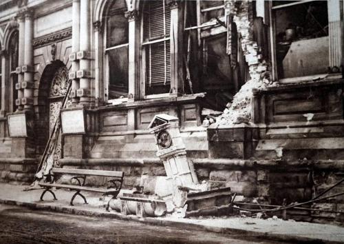 A photograph of the bombed Royal Hotel with debris on the street.