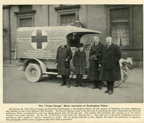 A black-and-white photograph of four people, including young Prince George, posing with a motorized ambulance.