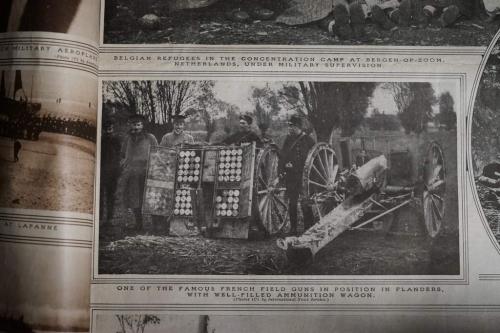 Une image en noir et blanc de cinq soldats français debout derrière un chariot plein de munitions.