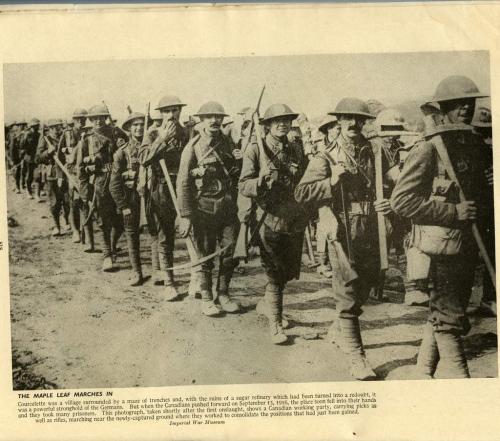 A black-and-white photograph of a long line of soldiers carrying picks.