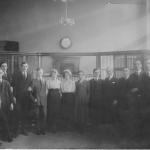 Une photographie en noir et blanc de Byron Cooper Sisler posant avec des collègues de la banque.