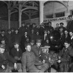Une photographie en noir et blanc de soldats canadiens assis autour d’un phonographe.