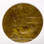 A bronzed round plaque inscribed with the words “He died for freedom and  Honour”.