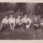 Une photographie en noir et blanc de Byron Cooper Sisler assis avec un groupe d’amis.