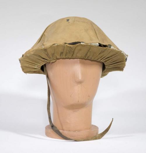 Un casque rond en acier avec une enveloppe en toile de couleur kaki.