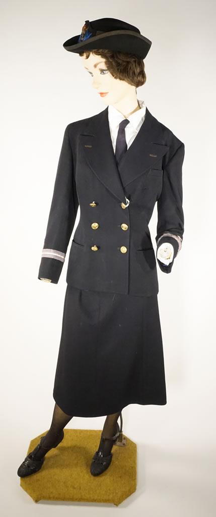 Un uniforme bleu marine consistant en une veste ajustée et une jupe aux genoux.