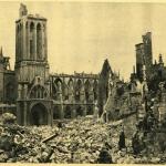 A black-and-white photograph of a church and a bombed-out street.