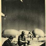Une photographie en noir et blanc de deux soldats faisant leur lessive avec de grands ballons flottant en arrière-plan.